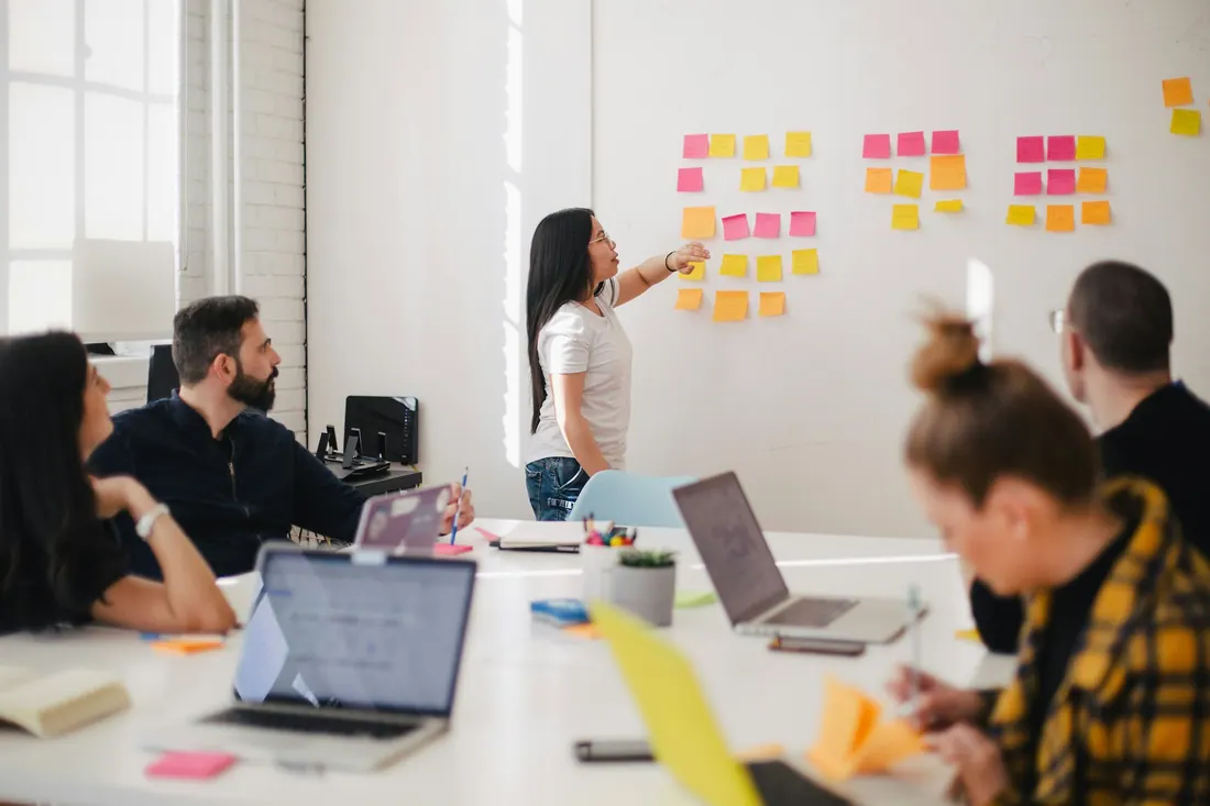 Team planning a project on a whiteboard with sticky notes
