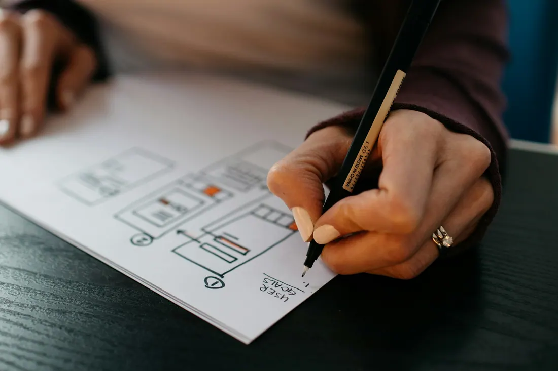 Designer sketching UI wireframes on paper